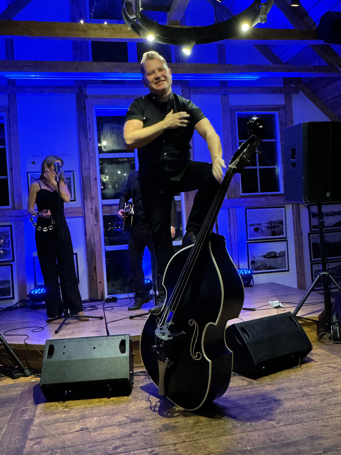 a man standing on a stage with a cello