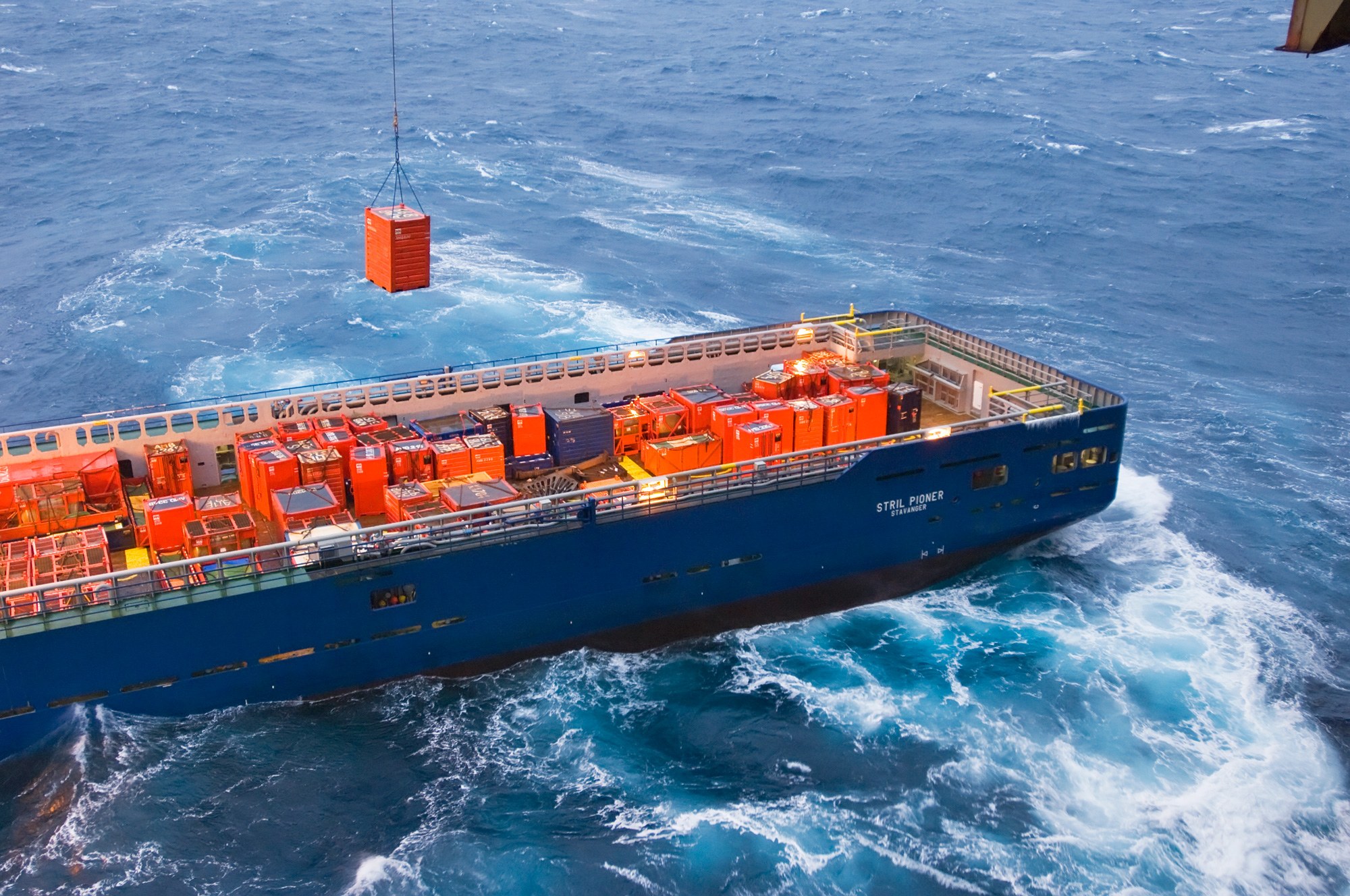 a large blue ship with orange boxes on the side