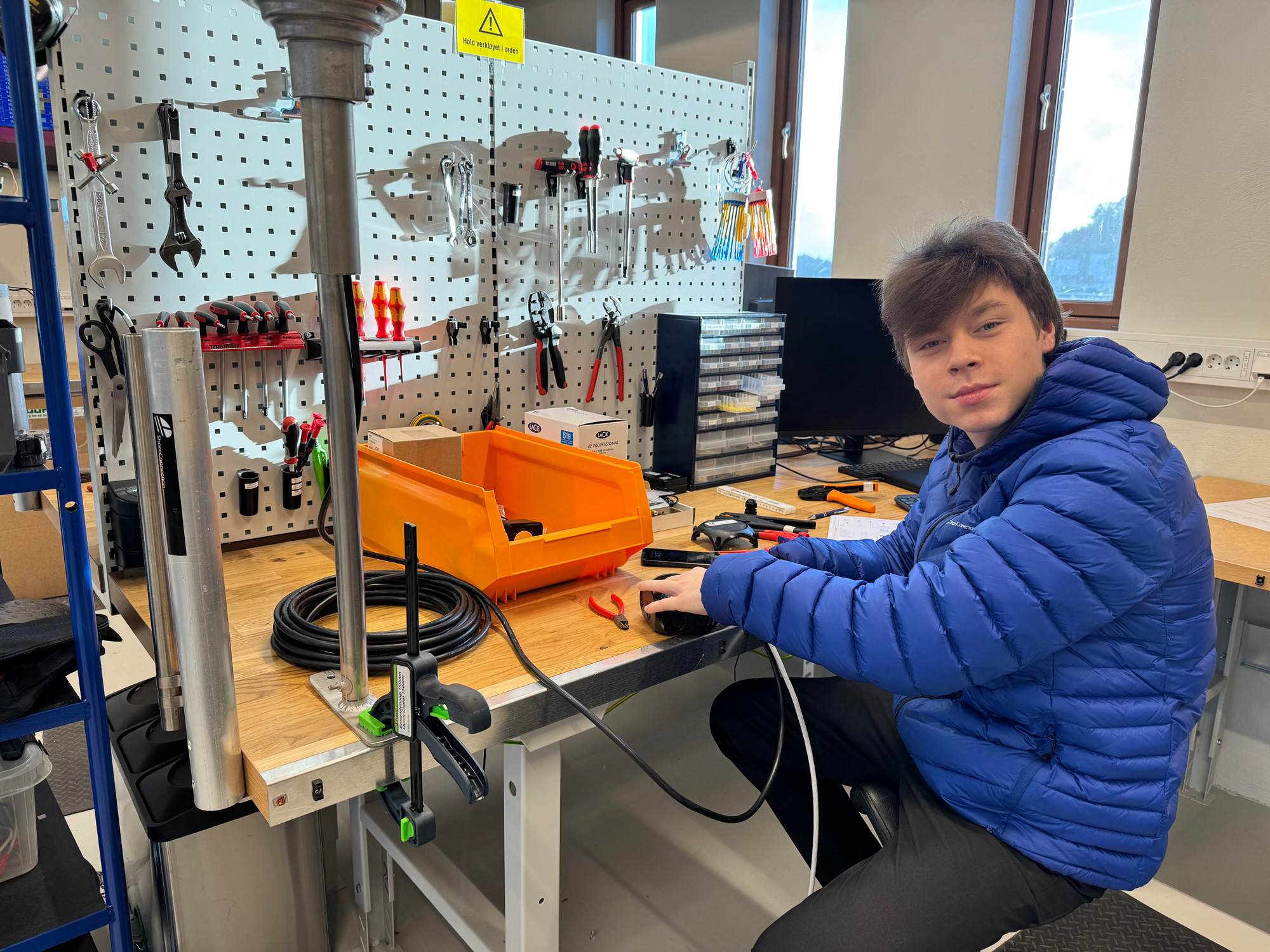 a man sitting at a desk with tools on it